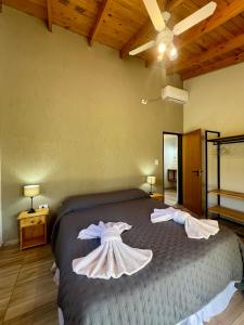 Un dormitorio con una cama con dos vestidos. en Refugio Serrano, en Merlo