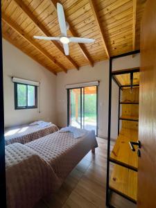 2 camas en una habitación con ventilador de techo en Refugio Serrano, en Merlo