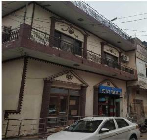 a white car parked in front of a building at Hotel O Vanshika in Agra +38 photos