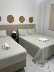 deux lits côte à côte dans une pièce dans l'établissement Apartamento em Santos no Gonzaga em frente a praia, à Santos