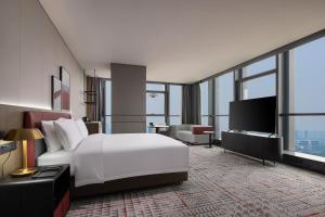 南昌市にあるRadisson Blu Hotel Nanchangのベッドとテレビがあるホテルの部屋