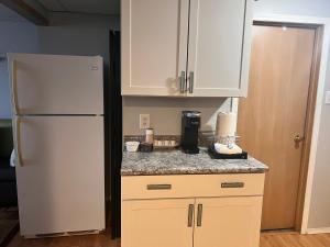 a kitchen with white cabinets and a refrigerator at Gull lake in Winnipeg