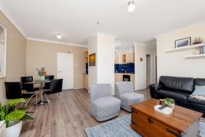 a living room with a couch and a table at WELL82 - Ocean Heights in Mosman Park
