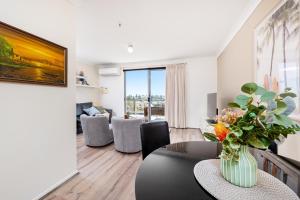 a living room with a vase of flowers on a table at WELL82 - Ocean Heights in Mosman Park