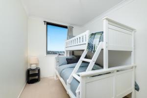 a white bunk bed in a white room with a window at WELL82 - Ocean Heights in Mosman Park +14 photos