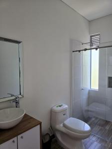 ein Badezimmer mit Toilette, Waschbecken und Dusche in der Unterkunft Casa de Descanso con Piscina y Jardín Ricaurte in Ricaurte