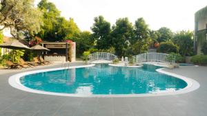 een groot zwembad met blauw water in een tuin bij LPP Garden Hotel in Yogyakarta