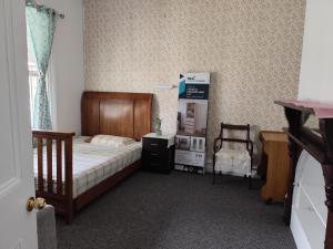 パースにあるKaivalya Niketanのベッドと箱と椅子のある寝室