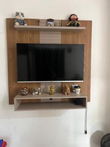 een entertainmentcentrum met een flatscreen-tv aan de muur bij Stúdio Viajante in Barcarena