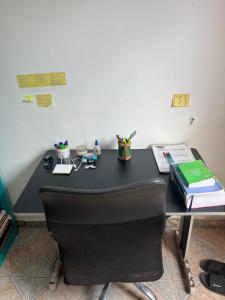een zwart bureau met een stoel in een kamer bij Stúdio Viajante in Barcarena