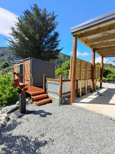 a patio with a wooden bench and a pavilion at Maungatapu Hut in Rai Falls