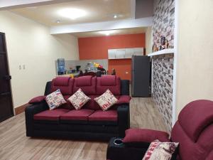 a living room with a red couch and a kitchen at Casa Cifuentes in La Esperanza