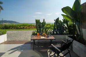a table and chairs on a patio with plants at Shenzhen White House Nan'ao Beach Seaview guesthouse in Youcaopeng