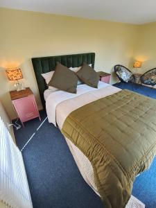 a bedroom with a large bed and two night stands at Maungatapu Hut in Rai Falls