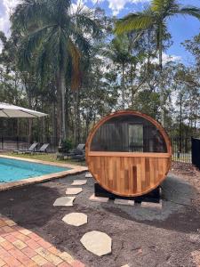 a wooden tub sitting next to a swimming pool at Lakeview Cottage in Mooloolah Valley in Mooloolah