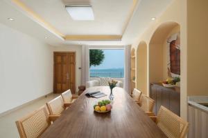 a dining room with a large wooden table and chairs at Shenzhen White House Nan'ao Beach Seaview guesthouse in Youcaopeng