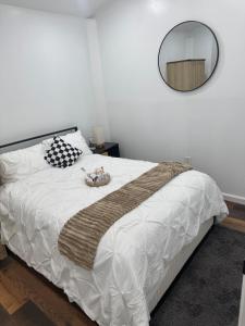 a bedroom with a large white bed with a mirror at Bright & Stylish Guest Suite with Modern Comforts in Selden