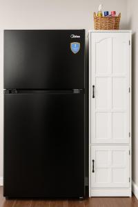 a black refrigerator next to a white door at Bright & Stylish Guest Suite with Modern Comforts in Selden