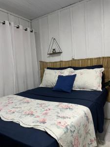 a bedroom with a bed with a blue comforter at Santo Gole Ilha Do Mel in Ilha do Mel