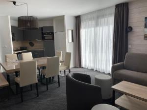 a living room with a table and chairs and a kitchen at Gourette: Appartement 8 pers, piscine, animaux admis - FR-1-860-14 in Gourette