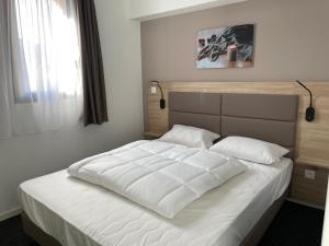 a bedroom with a large bed with white sheets at Gourette: Appartement 8 pers, piscine, animaux admis - FR-1-860-14 in Gourette +5 photos