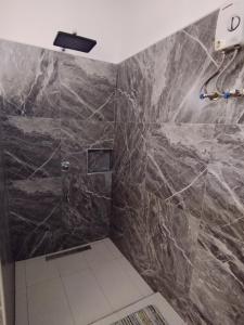 ボホールにあるDom's Oaseの黒大理石のシャワーブース付きのバスルーム