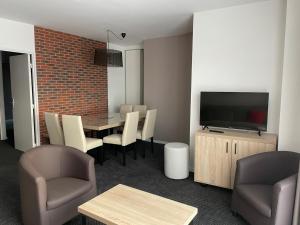 a living room with a table and chairs and a television at Appartement 8 pers, 2 pièces, piscine, animaux admis, Gourette - FR-1-860-23 in Gourette