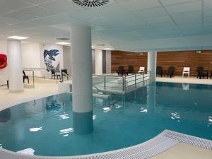 a swimming pool with blue water in a building at Gourette: Appartement 6 pers, 2 pièces, Animaux admis - FR-1-860-30 in Gourette