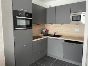 a kitchen with gray and white cabinets and appliances at Studio à Gourette, 6 pers, piscine et animaux admis - FR-1-860-35 in Gourette