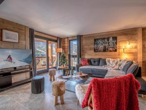a living room with a couch and a tv at Appartement rénové à Méribel, 3 chambres, accès skis, WIFI, parking - FR-1-688-99 in Mussillon
