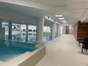 a swimming pool in a building with columns at Appartement 2 pièces, 6 pers, piscine, animaux acceptés - FR-1-860-40 in Gourette