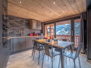a kitchen with a wooden table and chairs and a view at Appartement rénové à Méribel, 3 chambres, accès skis, WIFI, parking - FR-1-688-99 in Mussillon