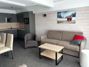 a living room with a couch and a table and a kitchen at Studio à Gourette avec Piscine et Animaux Admis pour 6 Pers. - FR-1-860-41 in Gourette