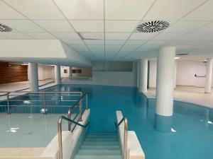 a swimming pool with blue water in a building at Appartement spacieux pour 8 personnes à Gourette avec piscine et animaux acceptés - FR-1-860-18 in Gourette
