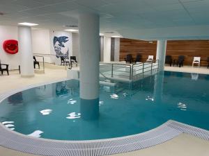 a swimming pool with blue water in a building at Charmant studio à Gourette avec piscine et animaux admis, pour 6 personnes - FR-1-860-26 in Gourette