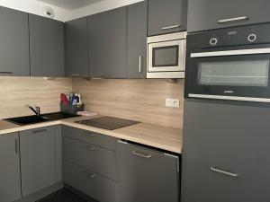 a kitchen with gray cabinets and a counter top at Appartement à Gourette - 6 pers, Piscine, Animaux admis - FR-1-860-27 in Gourette