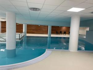 a swimming pool in a large building with columns at Studio douillet à Gourette - 6 personnes, draps inclus, animaux admis - FR-1-860-29 in Gourette