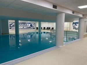 a swimming pool with blue water in a building at Gourette : Appartement 2 pièces, 6 pers, Animaux admis - FR-1-860-34 in Gourette