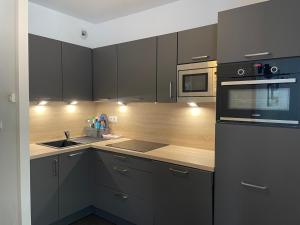 a kitchen with black cabinets and a counter top at Gourette : Appartement 2 pièces, 6 pers, Animaux admis - FR-1-860-34 in Gourette