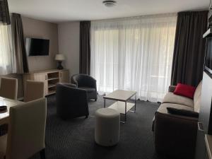 a hotel room with a couch and chairs and a television at Gourette : Appartement 3 pièces 6 pers, balcon, animaux admis - FR-1-860-39 in Gourette