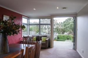 ニュープリマスにあるRelax on Richmond - modern beachside house retreatのテーブルと椅子と窓のあるダイニングルーム