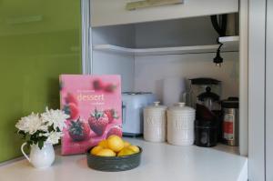 ニュープリマスにあるRelax on Richmond - modern beachside house retreatのキッチンカウンターの上に置かれた本とフルーツのボウル
