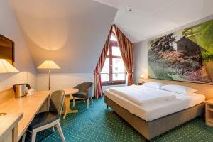 A bed or beds in a room at Mercure Hotel Erfurt Altstadt