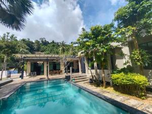 a swimming pool in front of a house at Villa89 Chumphon 