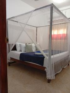 a bed with a canopy in a room at freedom house in Unawatuna
