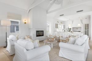 a white living room with white chairs and a fireplace at Farmhouse Hunter Valley in Pokolbin