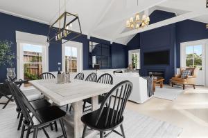 a dining room with blue walls and a table and chairs at Farmhouse Hunter Valley in Pokolbin