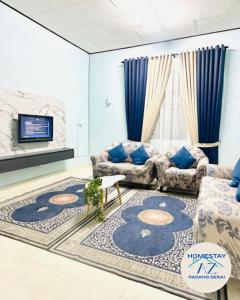 a living room with two couches and a rug at Homestay AZ Padang Serai in Padang Serai