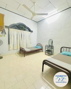 a hospital room with two beds and a window at Homestay AZ Padang Serai in Padang Serai
