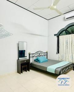 a bedroom with a bed and a television in it at Homestay AZ Padang Serai in Padang Serai